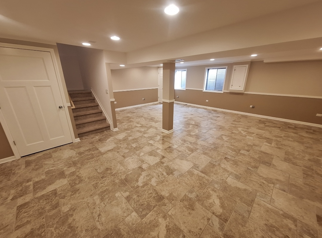 Finished basement with tile flooring and staircase